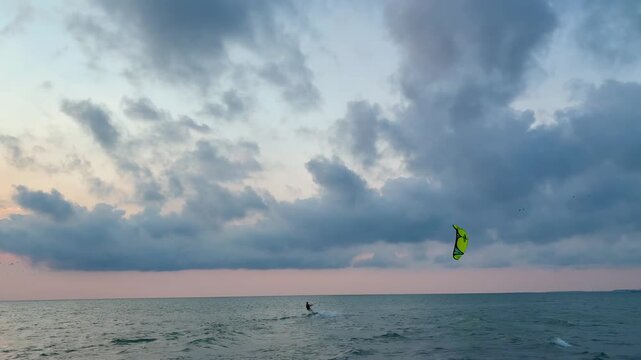 Kite surfer in the sea riding at sunset