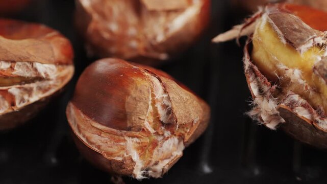 Grilled Fresh chestnut, supermarket food, grill Oven roasted chestnuts with sliced peel on wooden board, spanish traditional winter dish.