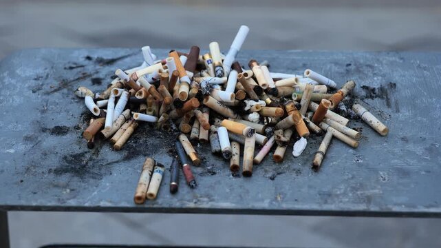 Discarded cigarette butts creating pollution and showing a public health issue