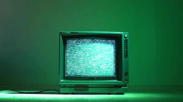 Retro TV, vintage television In a nostalgic setup, a retro TV displays grain on screen, scary halloween night device good for chroma key and green screen.