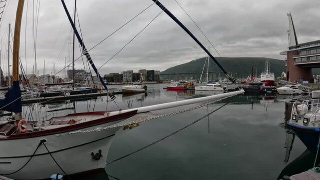 Sailboat bowsprit foreground in Tromso inner harbor marina Norway