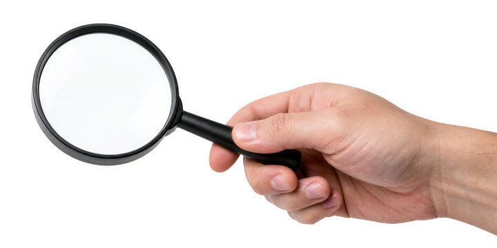 Man's hand holding a magnifying glass with bright lighting for close examination