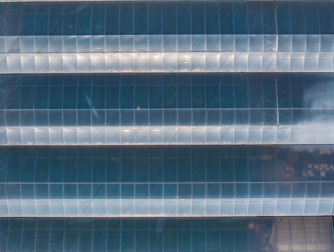Aerial view of greenhouse rooftops with repetitive glass panels in Vogelgrun, Grand Est, France.