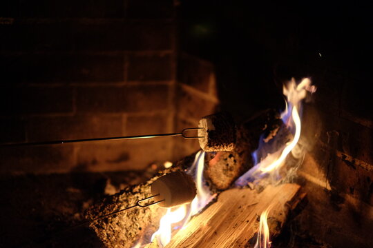 Fireplace burning mashmello to make smores