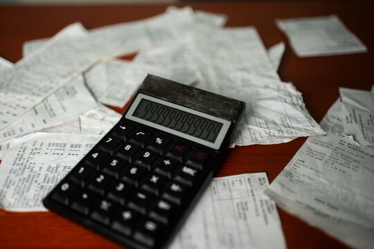 Horizontal shot of a calculator displaying numbers over scattered store receipts