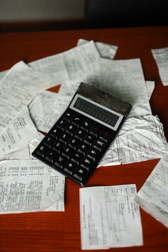 Overhead shot of a calculator displaying numbers on top of store receipts for personal finance