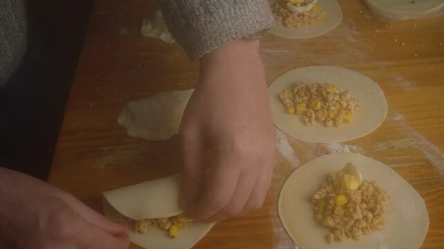 High Angle Shot of Hands Making Empanada Folding and Wrapping Dough
