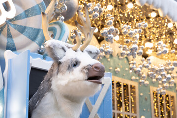 Reindeer figure with snow and decorations in a festive scene during a holiday celebration © ir1ska