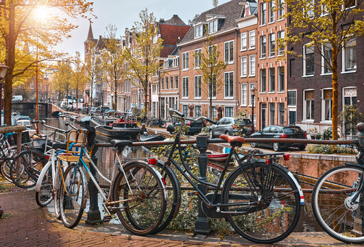 Bike over canal Amsterdam city. Picturesque town landscape in Netherlands with view on river Amstel..