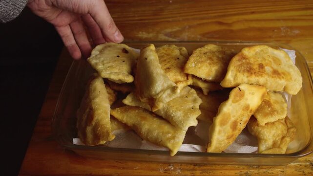 High Angle Shot of Hand Breaking Open Freshly Fried Crispy Empanada