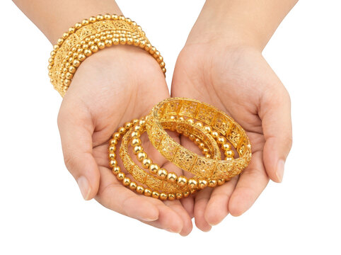 Closeup of hands holding a collection of elegant gold bangles and beaded bracelets isolated on transparent background