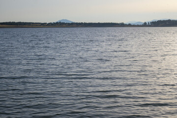 Calm lake with distant mountains at sunset © MiguelA