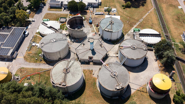 Aerial view of anaerobic digestion tanks at the Depuratore di Peschiera Borromeo sewage plant, showing wastewater treatment and energy infrastructure in Peschiera Borromeo, Lombardy, Italy.