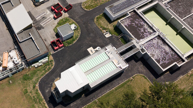 Aerial view of the Depuratore di Peschiera Borromeo wastewater treatment plant with its industrial buildings and water filtration tanks in Peschiera Borromeo, Lombardia, Italy.