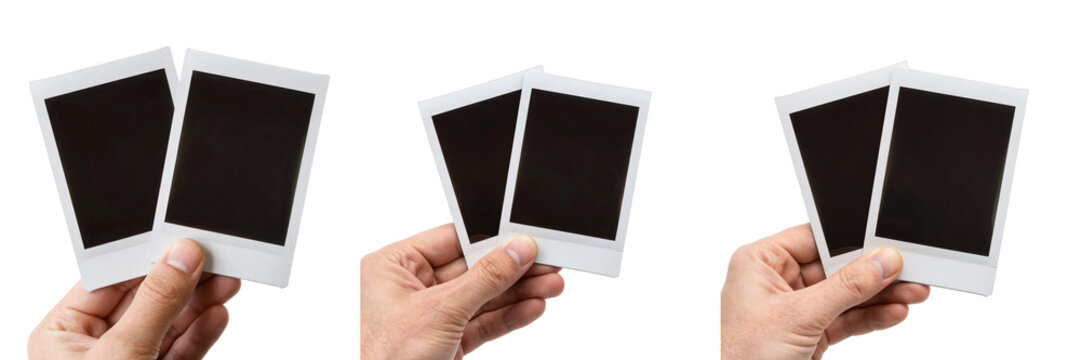 Hand holds two blank instant photos on a black background in different positions