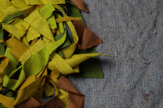 Colorful fabric scraps on burlap background with copy space, sustainable textile concept