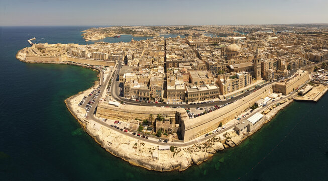 Aerial view of the historic city of Valletta with limestone buildings, St. Paul's Pro-Cathedral, and fortifications overlooking the Grand Harbour in Valletta, Port Region, Malta.