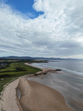 Dornoch is a historic Highland town overlooking the sea and Dornoch Firth, known for its cathedral, castle, sandy coast, and blue skies.