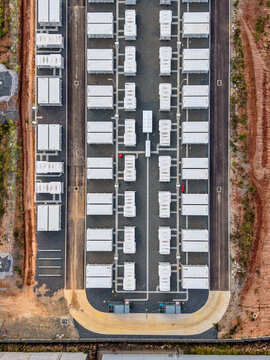 Aerial view of the Brendale BESS facility, featuring rows of white battery storage containers on a gravel site with paved access paths in Brendale, Queensland, Australia.