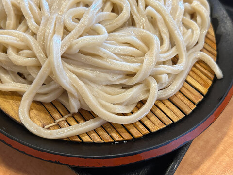 手打ち太麺のざるうどん、竹ざるに盛られた冷やしうどん定食