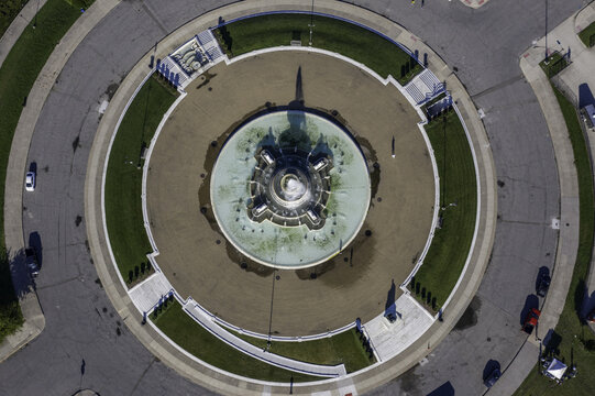 Aerial view of the James Scott Memorial Fountain in Belle Isle Park, surrounded by circular walkways, green lawns, and paved roads in Detroit, Michigan, United States.
