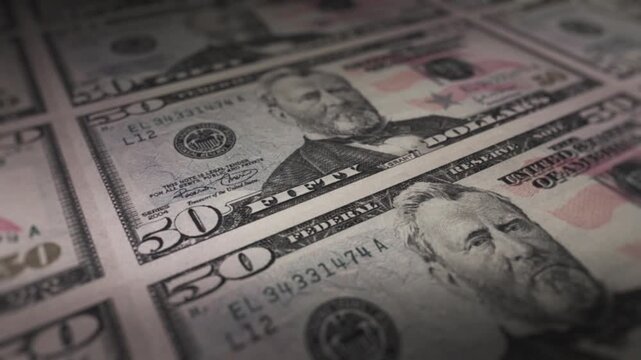 Banknotes of fifty dollars are laid out in a grid pattern to show a large quantity of currency.