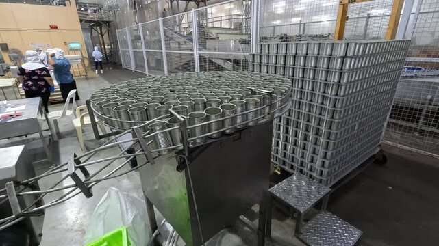 Can factory workers prepare metal cans for production in a large facility?