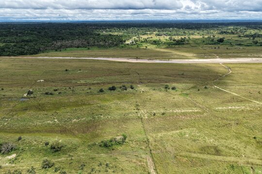Vista a&eacute;rea de dron sobre paisaje rural con campos verdes, bosques y el rio.