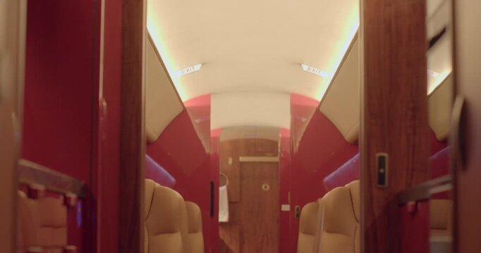 Elegant private jet cabin layout. Comfortable seating with wood accents and soft lighting. Calm and sophisticated environment emphasizing spaciousness and tranquility
