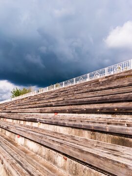 Empty wooden bleachers with dramatic cloudy sky