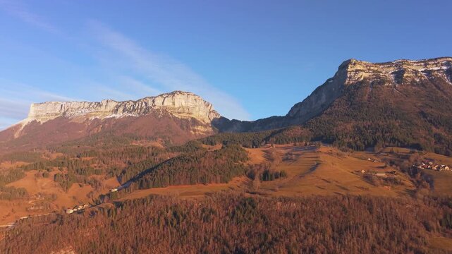 Vue a&eacute;rienne en drone sur les paysages montagneux du massif de la Chartreuse baign&eacute;s par la lumi&egrave;re dor&eacute;e du coucher du soleil.