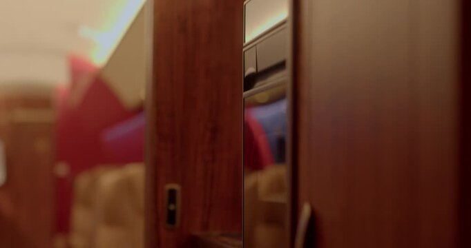 Wood handle closeup. Close view of cabinet handle and sliding mechanism. Focused photograph showcasing wooden cabinet handle along with sliding components and warm illumination