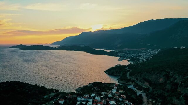 Kas Antalya coastal sunset aerial view highlighting dramatic red horizon and calm Mediterranean water. Cinematic drone camera moving toward the sea.