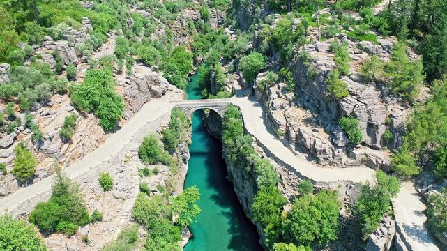 Koprulu Canyon aerial drone view reveals turquoise river waters winding through dramatic cliffs and lush forests in Manavgat, Antalya, Turkey.