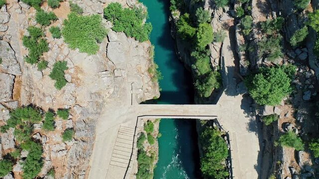 Koprulu Canyon stretches through lush forests and rugged cliffs, with a turquoise river flowing below in a breathtaking aerial view of Antalya.