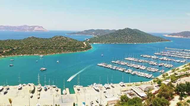 Kas, Antalya marina aerial view showcasing luxury yachts and boats docked at the harbor in Turkey. Majestic drone shot flying over turquoise sea and coast.