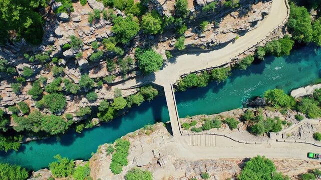 Koprulu Canyon aerial drone view reveals turquoise river waters winding through dramatic cliffs and lush forests in Manavgat, Antalya, Turkey.