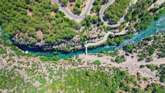 Koprulu Canyon aerial drone view reveals turquoise river waters winding through dramatic cliffs and lush forests in Manavgat, Antalya, Turkey.