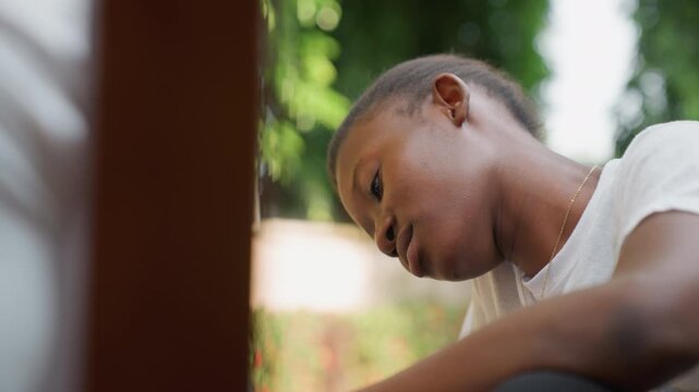 Intimate couple amidst lush garden surroundings. Black man and woman exchanging tender gazes in foliage. Romantic couple immersed in serene garden setting during heartfelt confession
