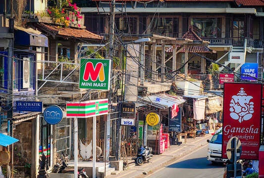 08 02 2026 - Ubud, Bali. Busy street in Ubud, Bali, Indonesia, lined with numerous shops, colorful advertising signs and local businesses, the vibrant atmosphere of a popular tourist destination