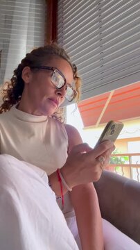Woman with glasses scrolling on her mobile phone
