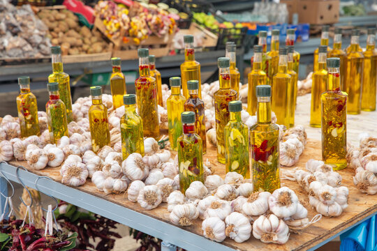 Bottled olive oil and garlic bulbs at market stall, Croatia.
