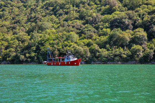 Red fishing boat moored in Lim Fjord, Istria, Croatia.