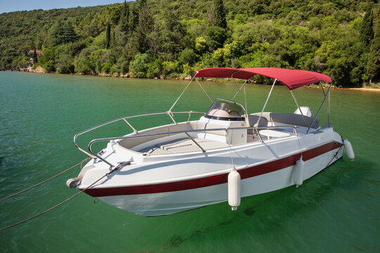 Modern motorboat with red canopy moored in Lim Fjord, Croatia.
