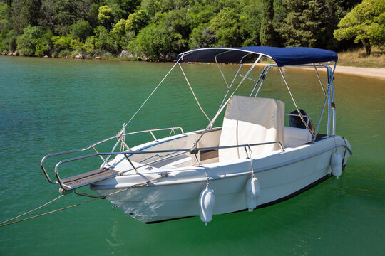 Modern motorboat with red canopy moored in Lim Fjord, Croatia.
