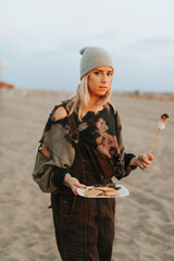 Naklejka premium Woman having a s'more at the beach