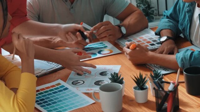 Top view of business people working together to choosing color from color palette. Project manager present idea by using tablet to marketing team while business man looking at logo graphic. Symposium.