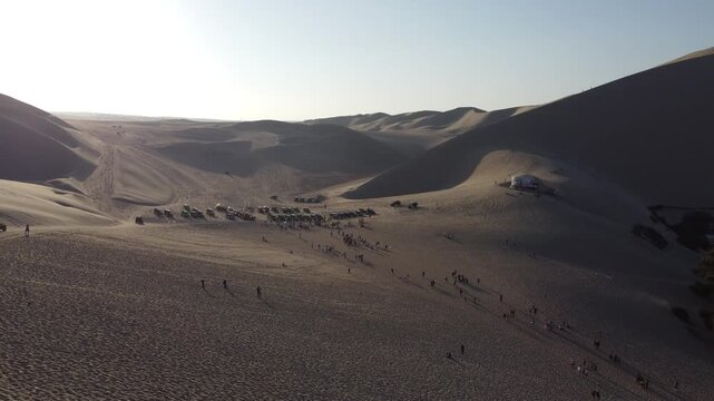 Tourists enjoying dune buggy and sandboarding in huacachina desert, peru