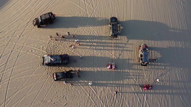 Aerial view of buggy pulling tourists in huacachina desert