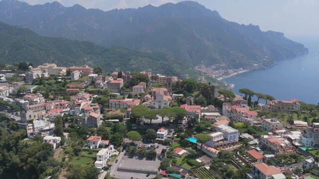 Aerial view of the historic town of Ravello nestled on the cliffs overlooking the Mediterranean Sea with lush greenery and traditional architecture in Ravello, Campania, Italy.